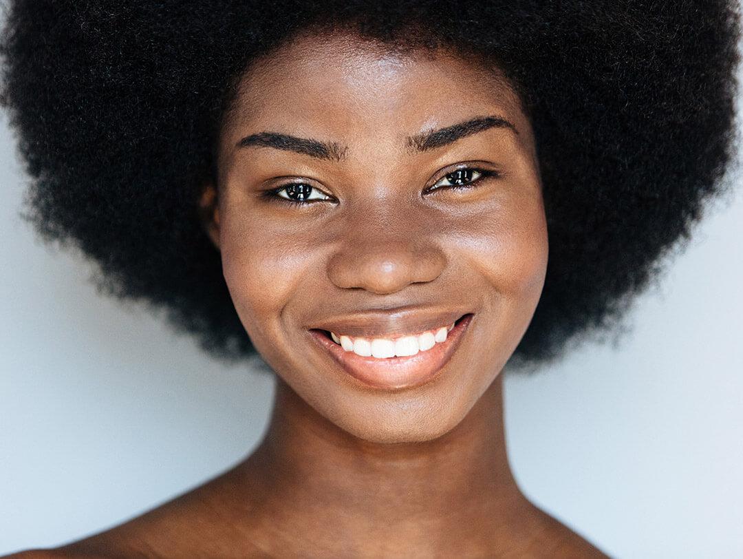 Close-up of a smiling beautiful Black woman with clear skin Desktop