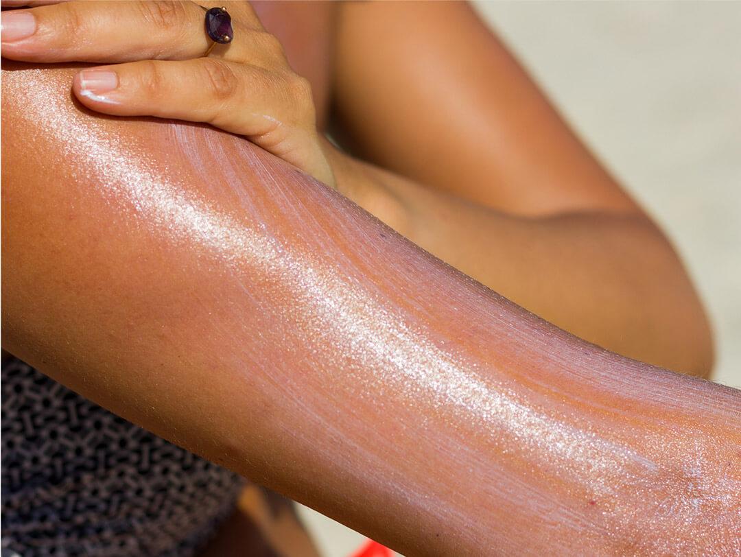 A photo of a model applying sunscreen on arm Desktop