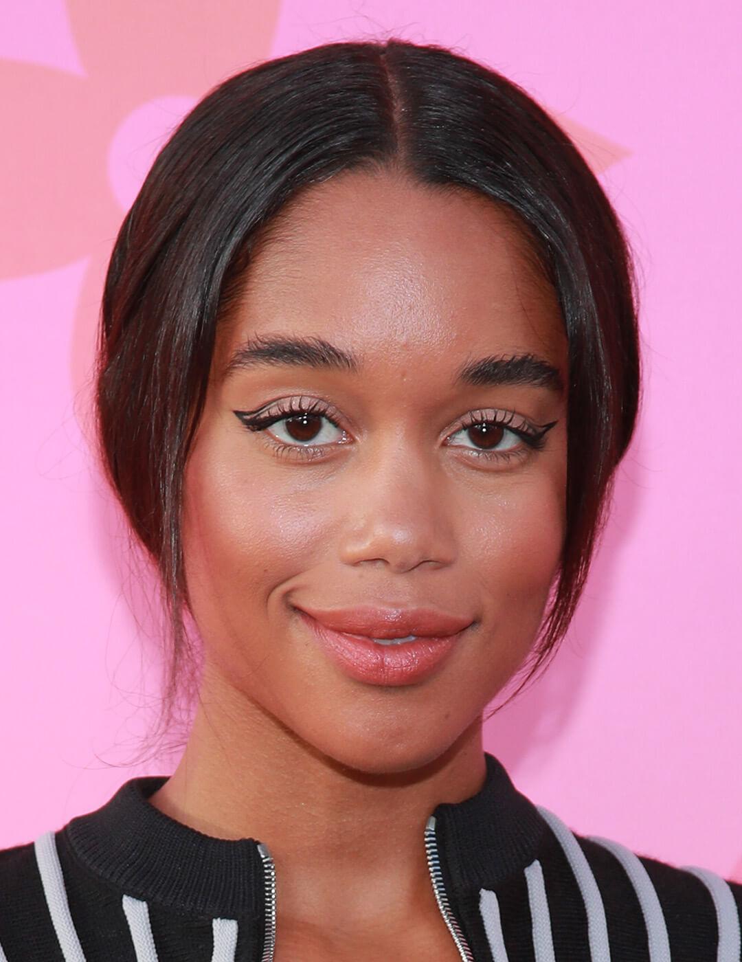 Close-up look of Laura Harrier rocking a minimal makeup look, low ponytail, wearing black and white striped top Mobile