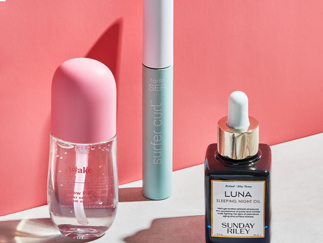 Image of skincare and makeup products against a coral pink background Desktop