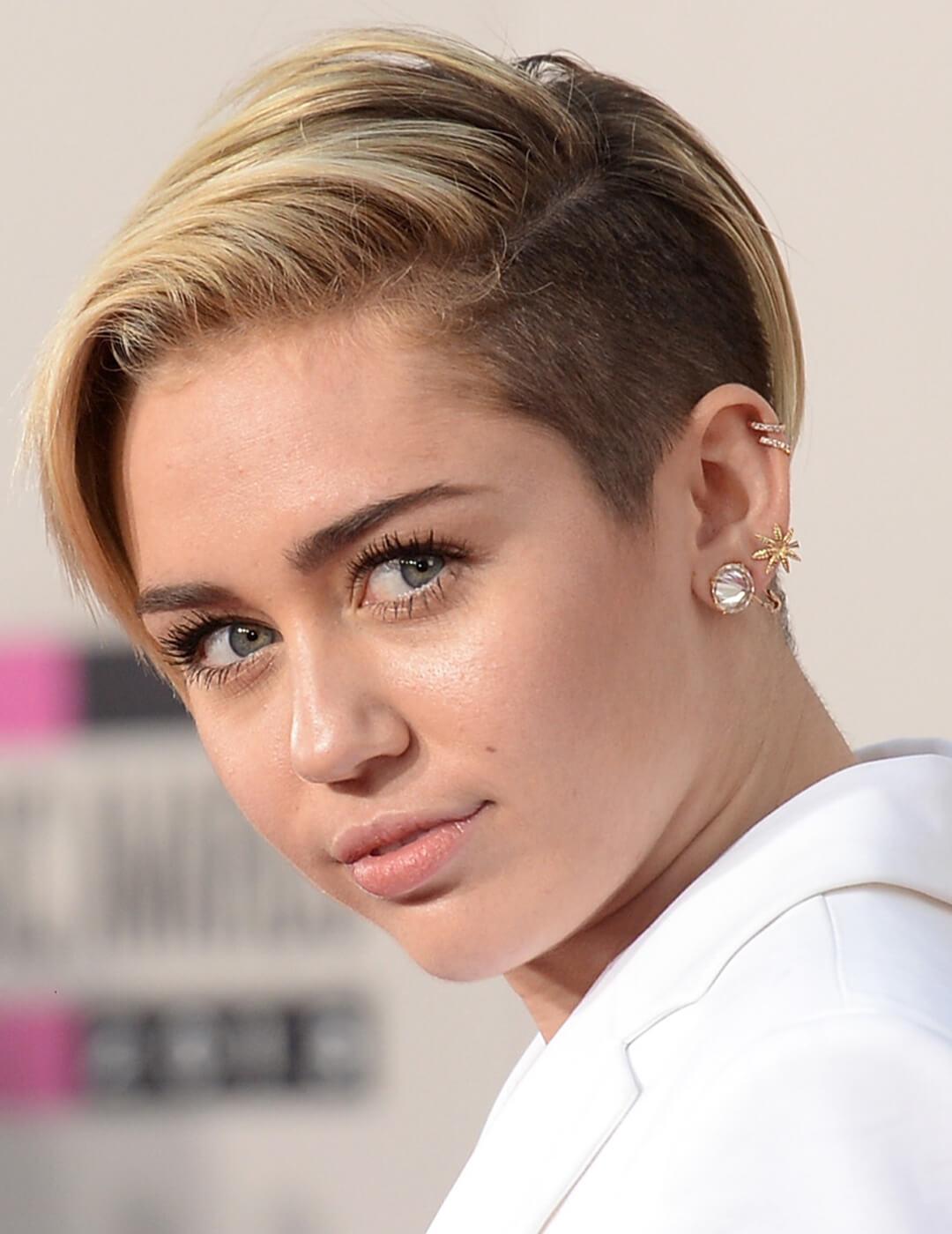 Close-up of Miley Cyrus rocking a long pixie undercut hairstyle and white suit Desktop