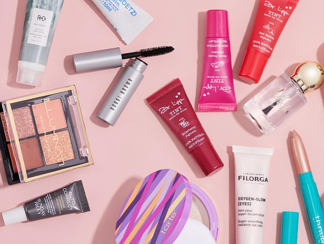 Makeup, skincare, and nail products from IPSY November 2020 Glam Bag Ultimate on pink background Desktop