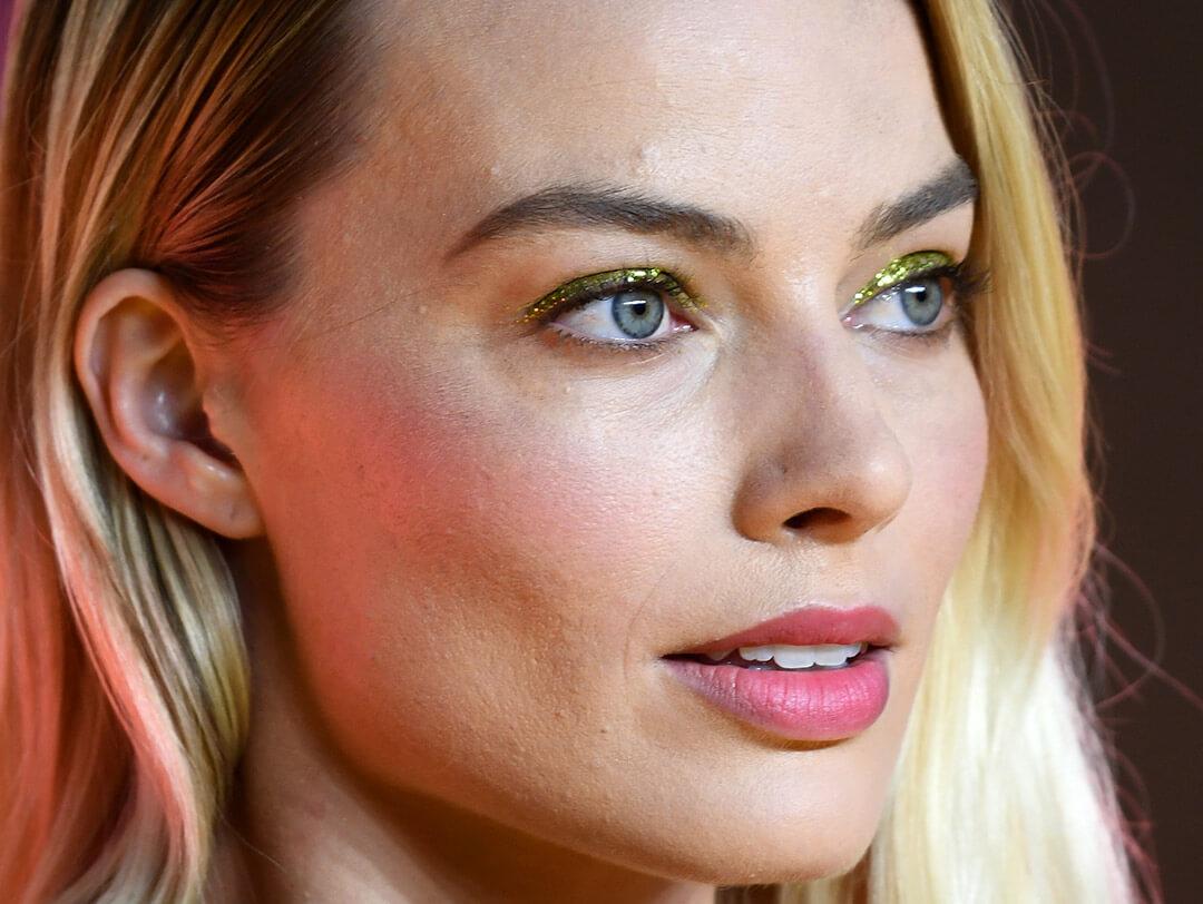 Close-up of Margot Robbie rocking a glittery gold eyeshadow look paired with soft pink lips Desktop