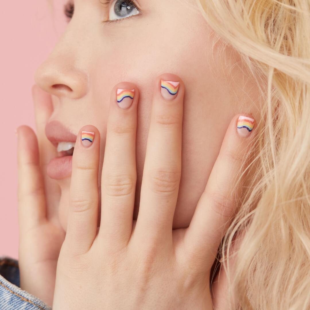 Close-up of a model showing off her rainbow waves nail art mani Desktop