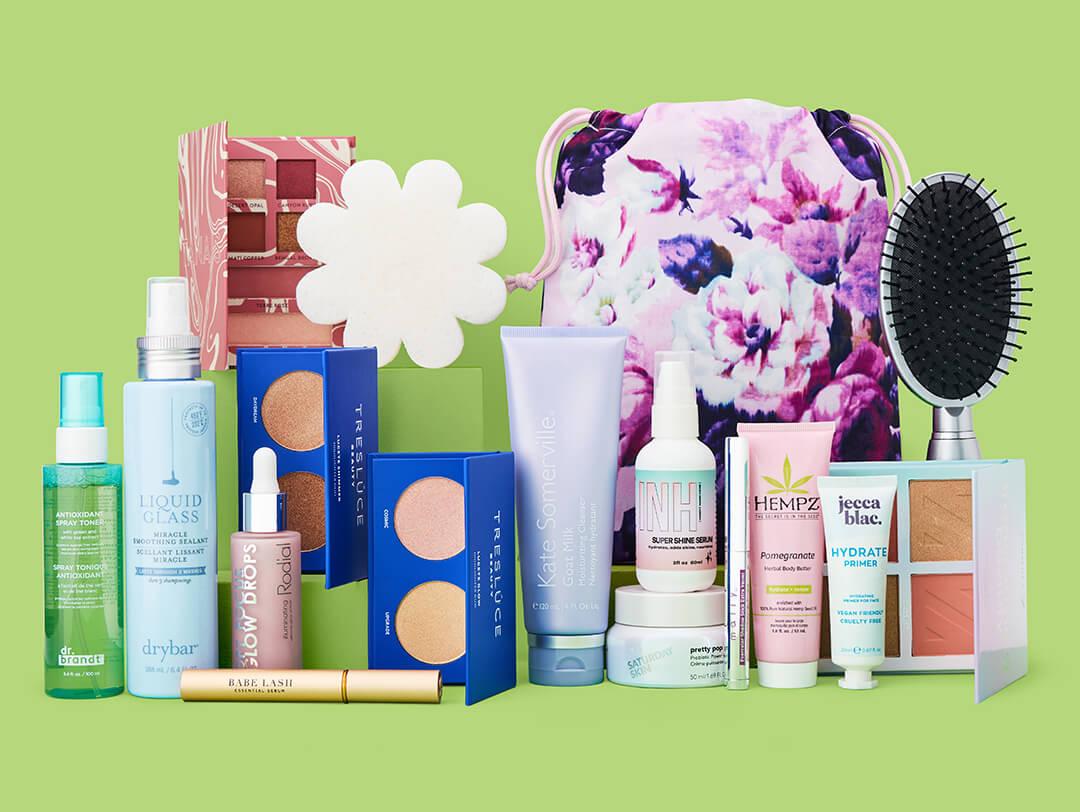 Makeup, skincare, and beauty products and tools from various brands neatly arranged on green background Desktop