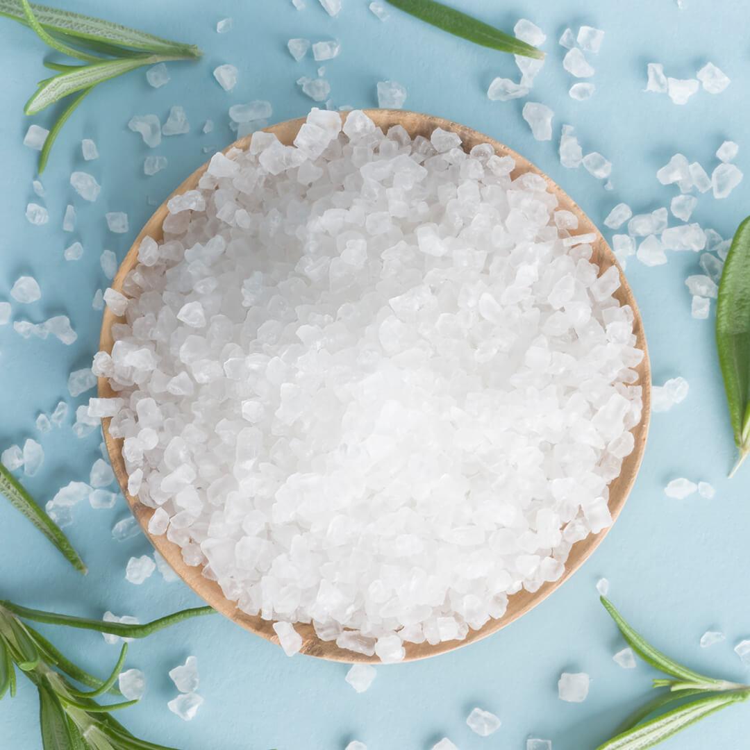 A photo of sea salt in bowl and rosemary on a blue background Mobile