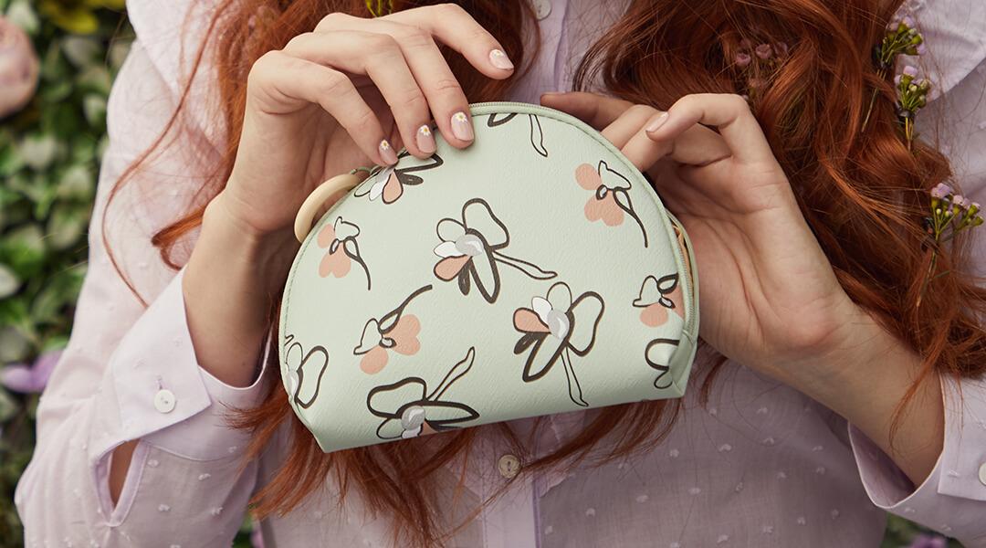 An image of a model opening up a Glam Bag. Desktop