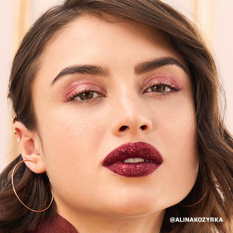 An image of a model wearing glossy rose gold eye shadow and glittery dark berry lipstick Desktop