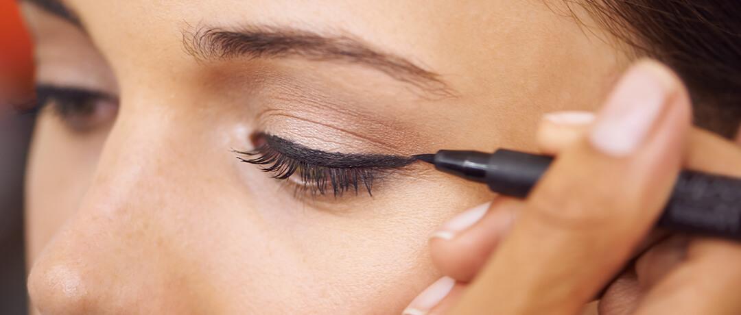 Close-up image of a woman applying liquid eyeliner Desktop