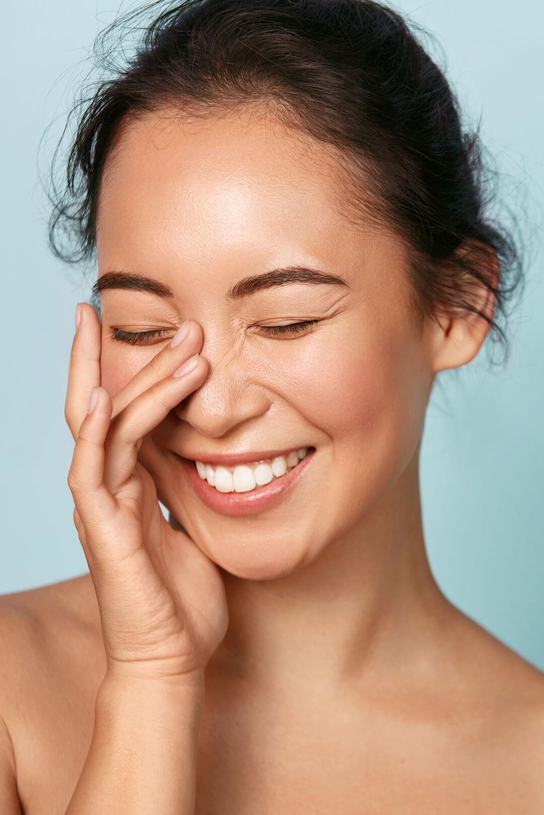 A photo of a smiling woman with healthy glowy skin Desktop