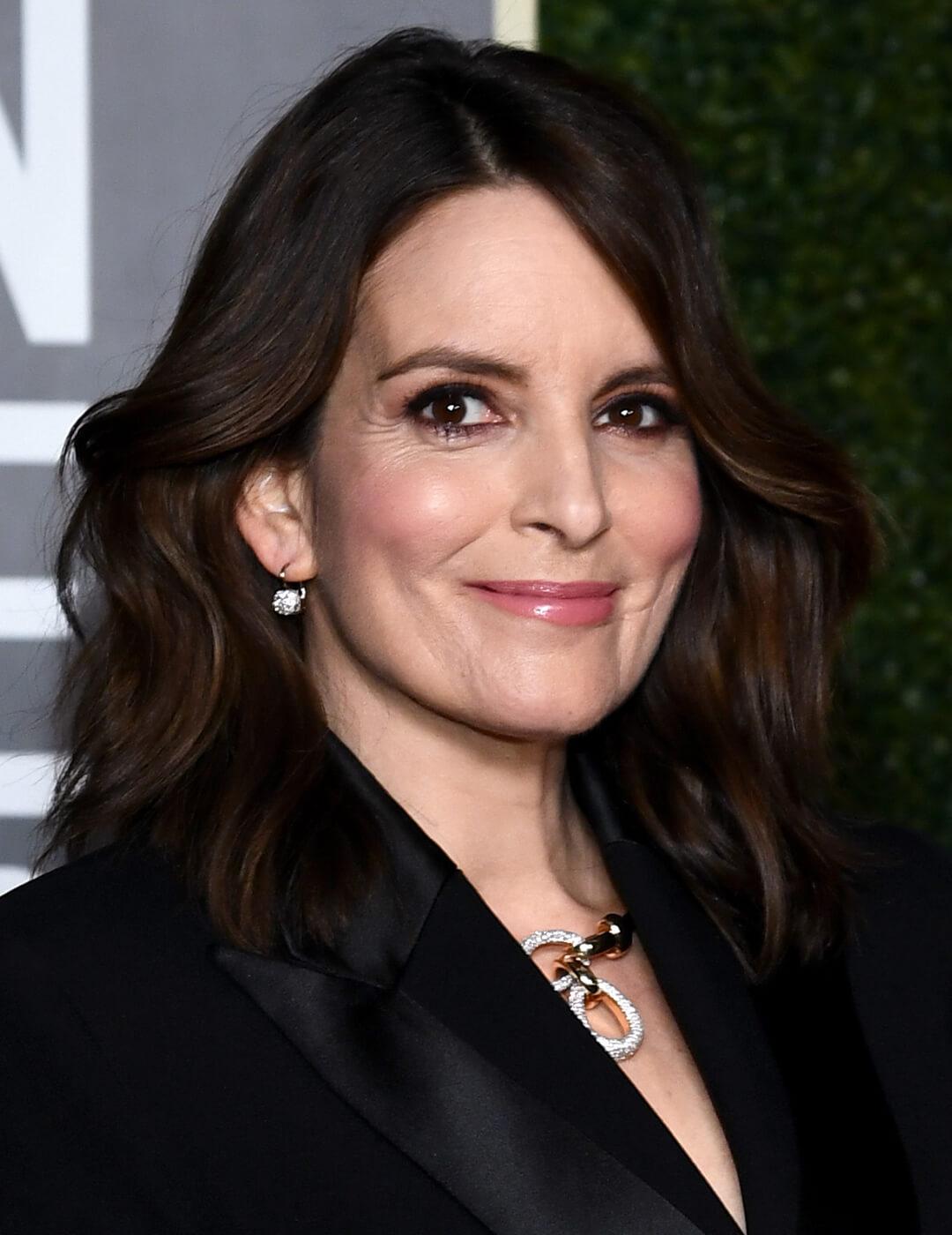 Tina Fey looking glam in a voluminous hairstyle and black suit Mobile