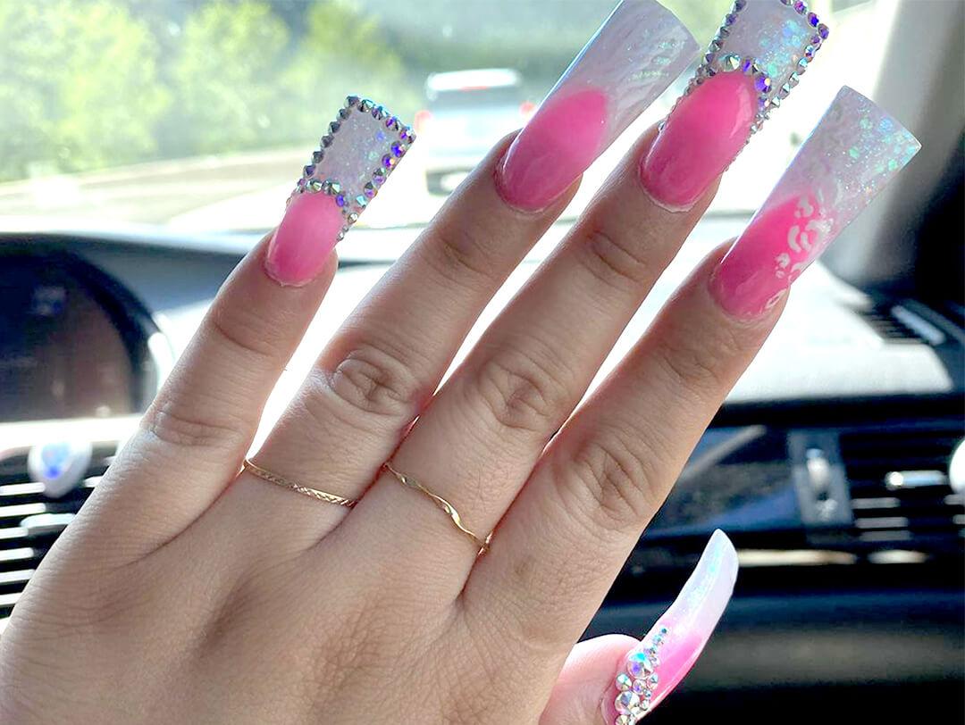 Close-up of a woman's hand with sparkly white and pink duck nails nail art Desktop