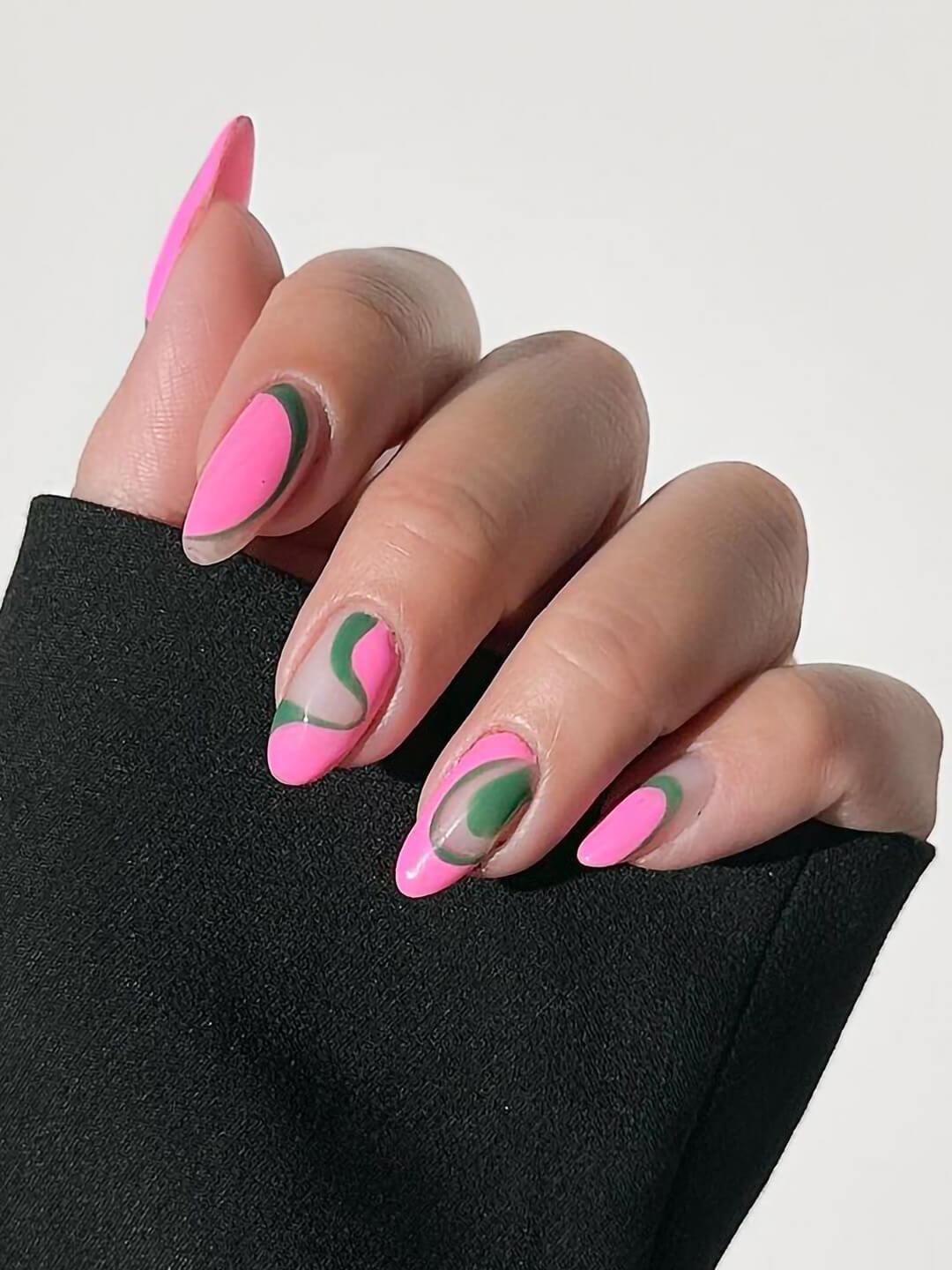 Close-up of a woman's hand with pink and green swirly nail art Desktop