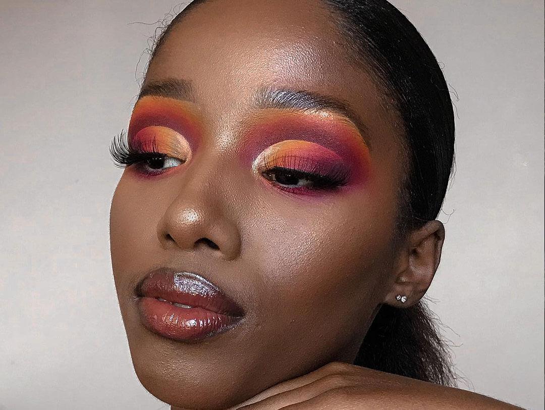 Woman with a dramatic red wine makeup look, adorned with rich hues of red and burgundy, blended seamlessly to create a striking eyeshadow gradient that resembles the essence of red wine Desktop