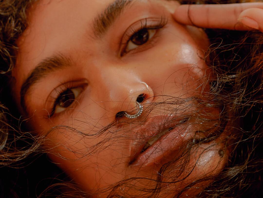 A closeup of a model looking into the camera with healthy looking skin Desktop