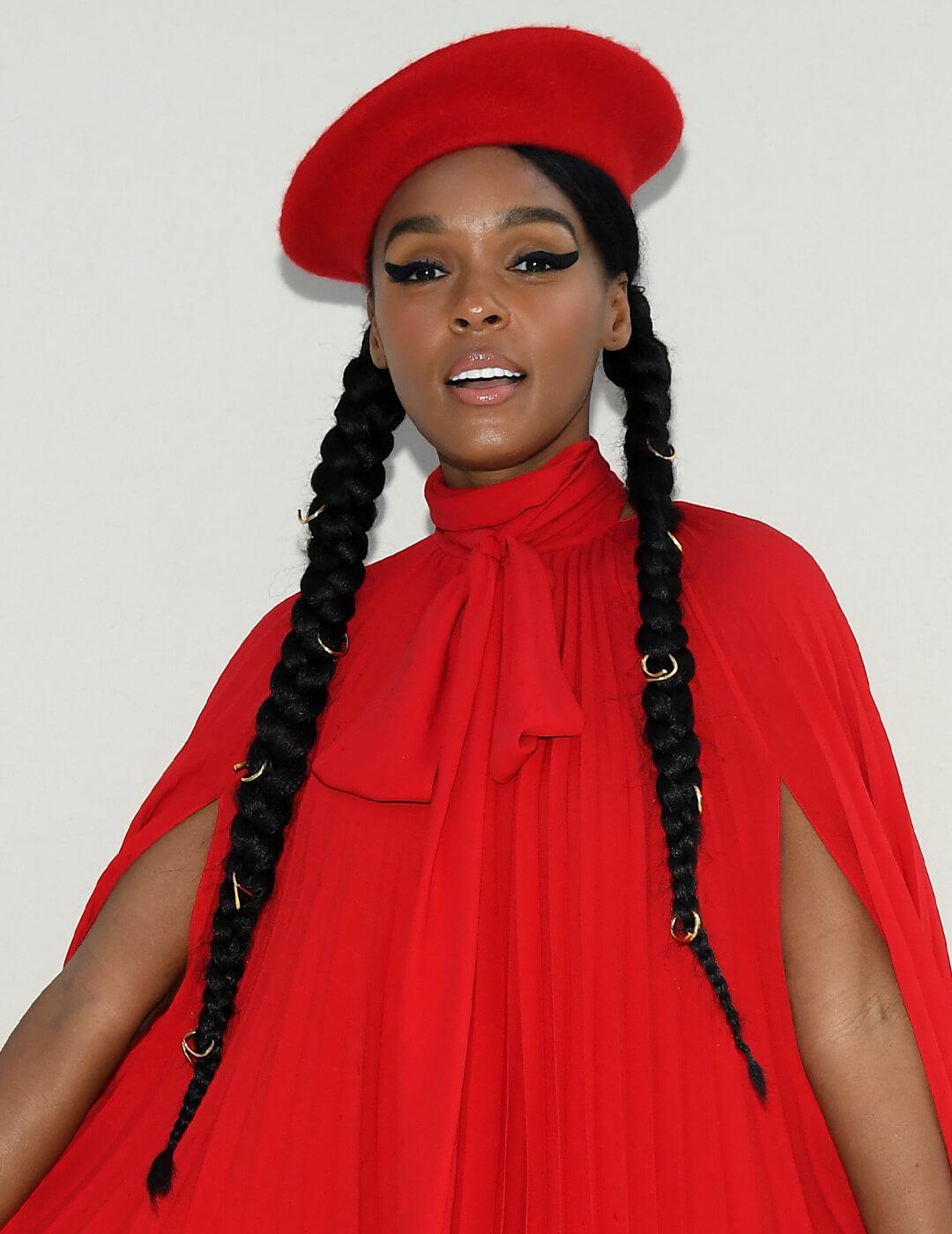 Janelle Monae going bold with a red dress, thick cat eye look, and braided pig tails with gold accents Mobile