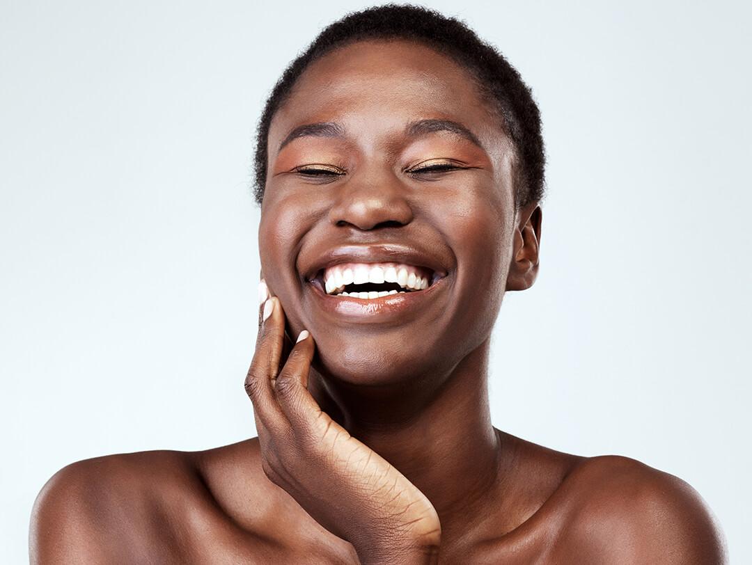 Studio portrait of a smiling Black woman with clear skin Desktop