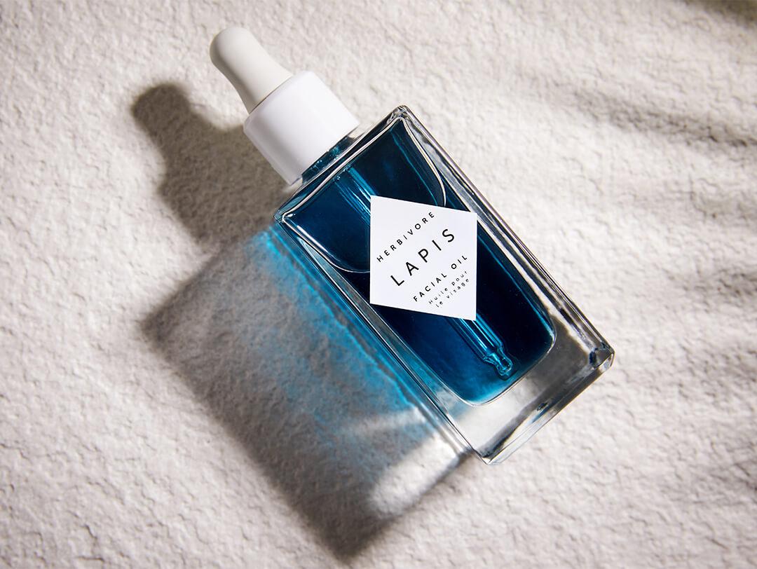 HERBIVORE Lapis Blue Tansy Face Oil on gray rough surface Desktop