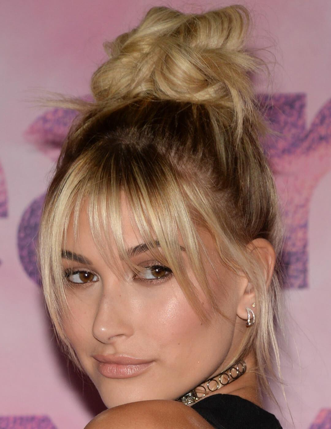 A photo of Hailey Bieber wearing a chic black top elegantly baring her shoulders adorns a necklace that resembles a stylish bangle Desktop