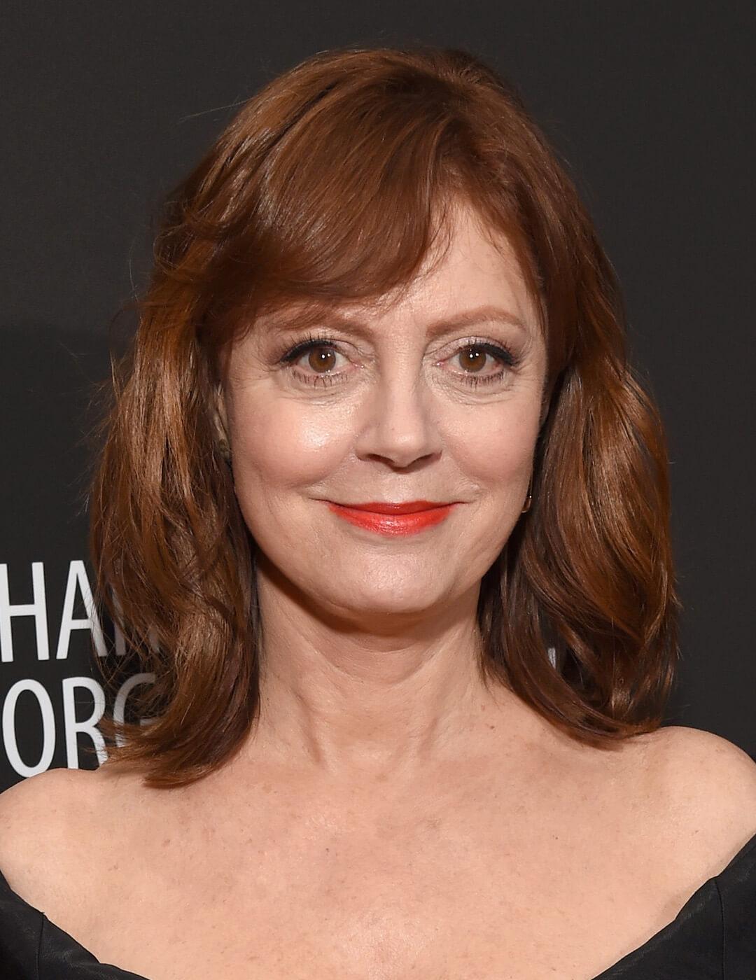 A photo of Susan Sarandon wearing a black dress and bangs hairstyle Mobile