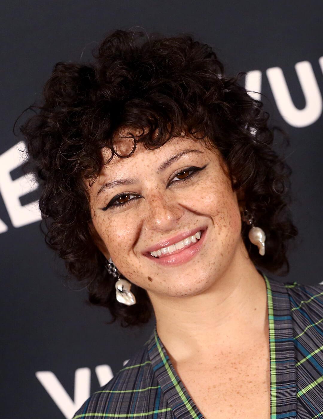 Smiling Alia Shawkat rocking a short curly hairstyle with wispy bangs Desktop