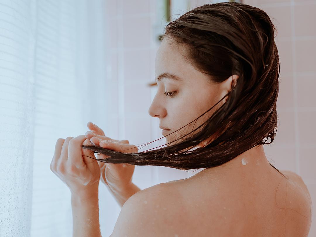 A photo of a woman taking a shower and washing her hair Desktop