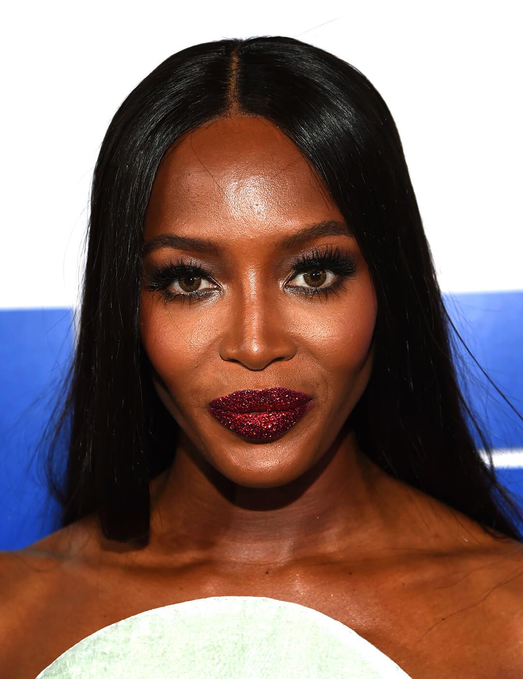 Close-up of Naomi Campbell rocking a smoky eye makeup look paired with glittery dark red lips Mobile
