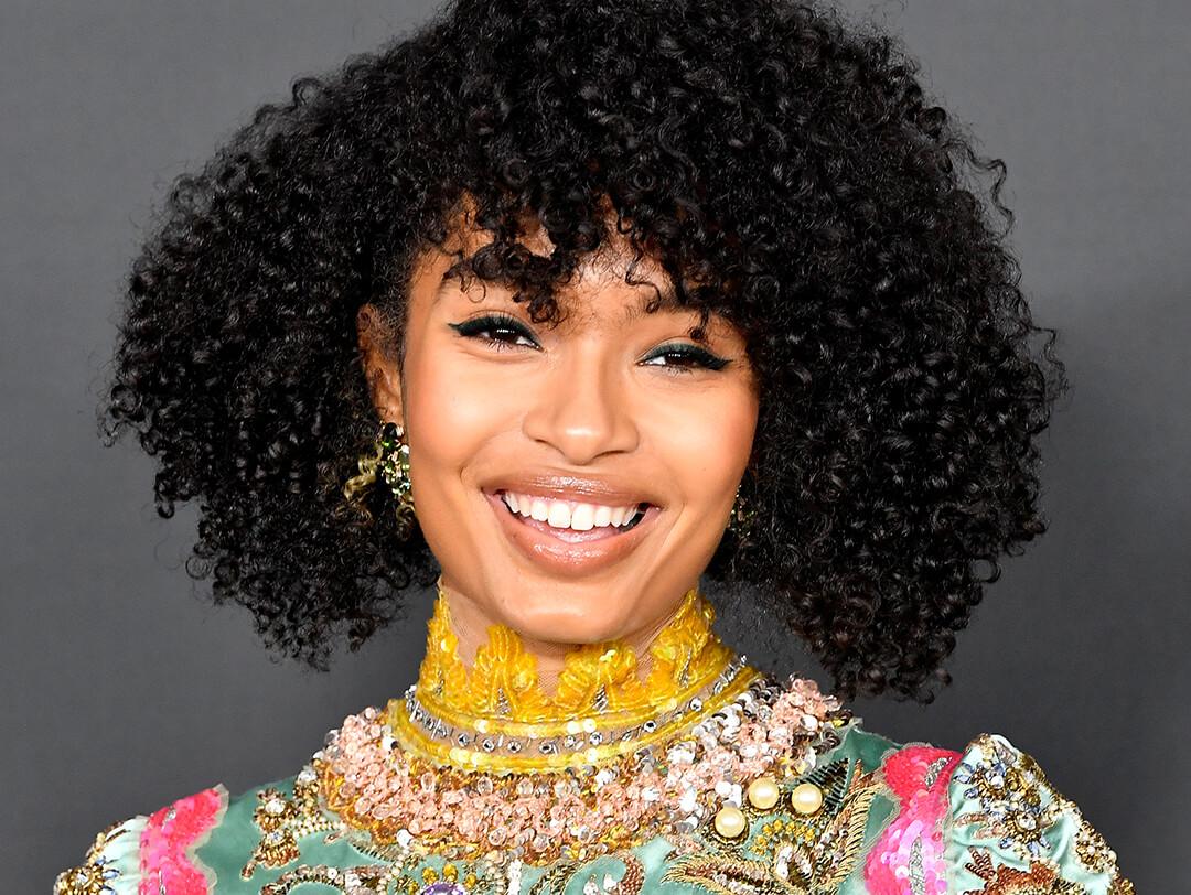 A photo of Yara Shahidi beaming a wide smile with her black kinky hair Desktop