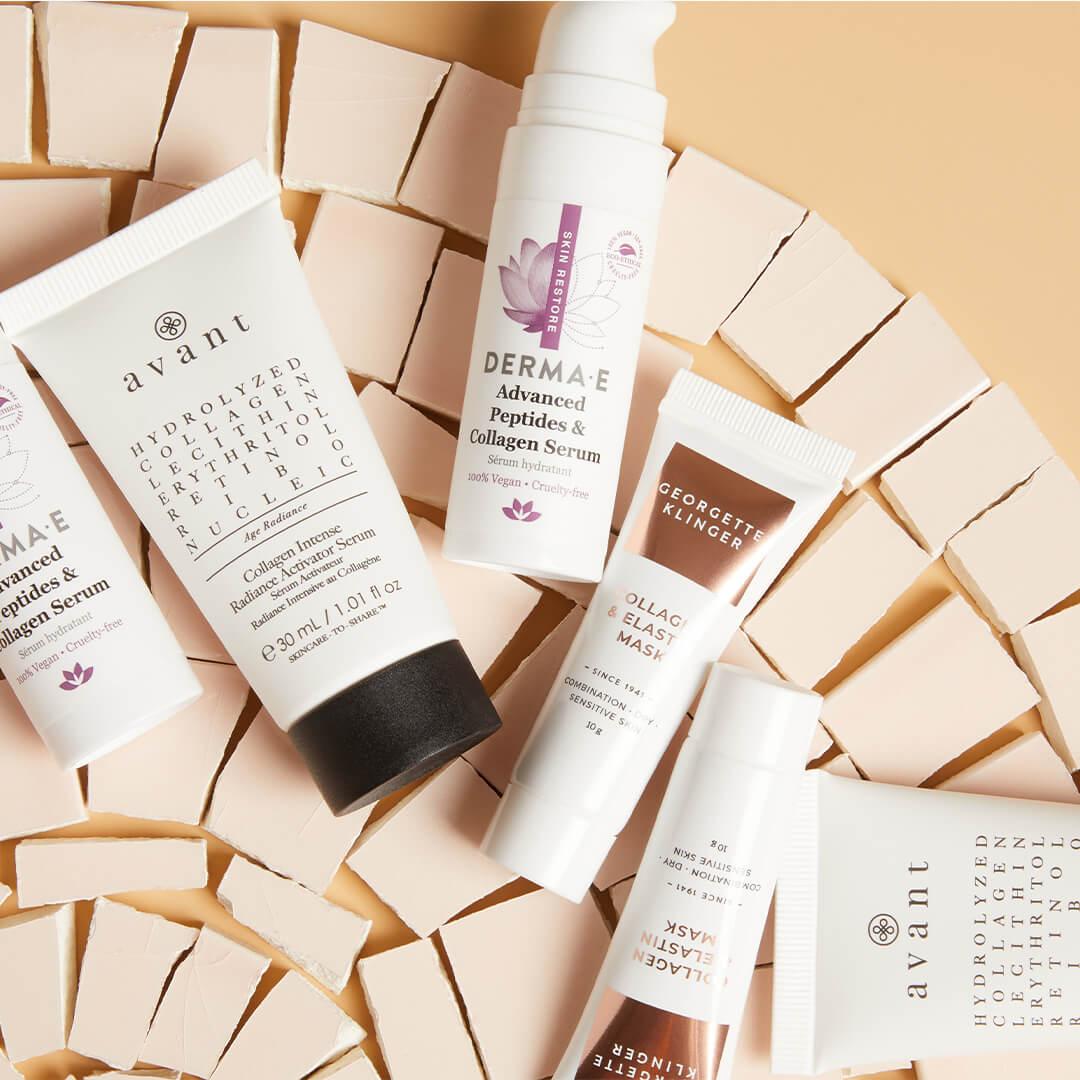 Collagen-based skincare products on top of tiny cream cardboard boxes against dark cream background Mobile