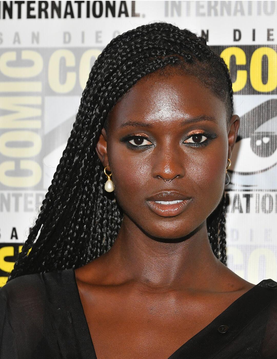 Jodie Turner-Smith in a black dress rocking a side-swept braided hairstyle Mobile