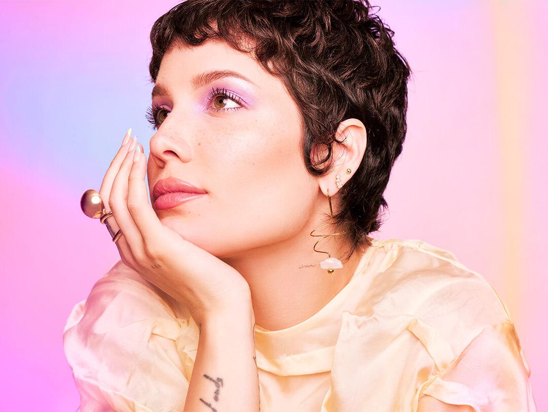 Side profile image of Halsey looking chic and posing against colorful background Desktop