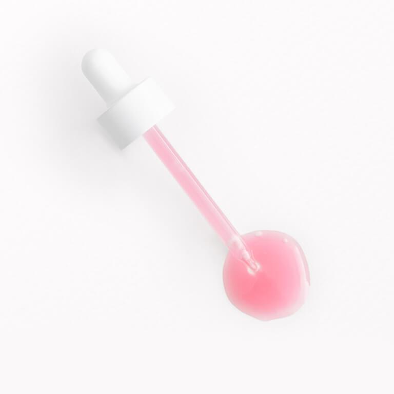 An image of a white dropper with pink liquid serum Desktop