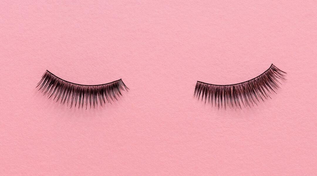 Image of a pair of false eyelashes on pink background Desktop