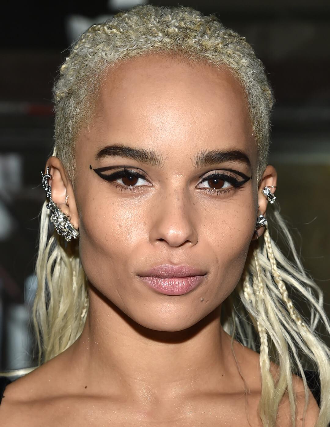 Zoë Kravitz rocking a blonde braided hairstyle and graphic eye makeup look Mobile