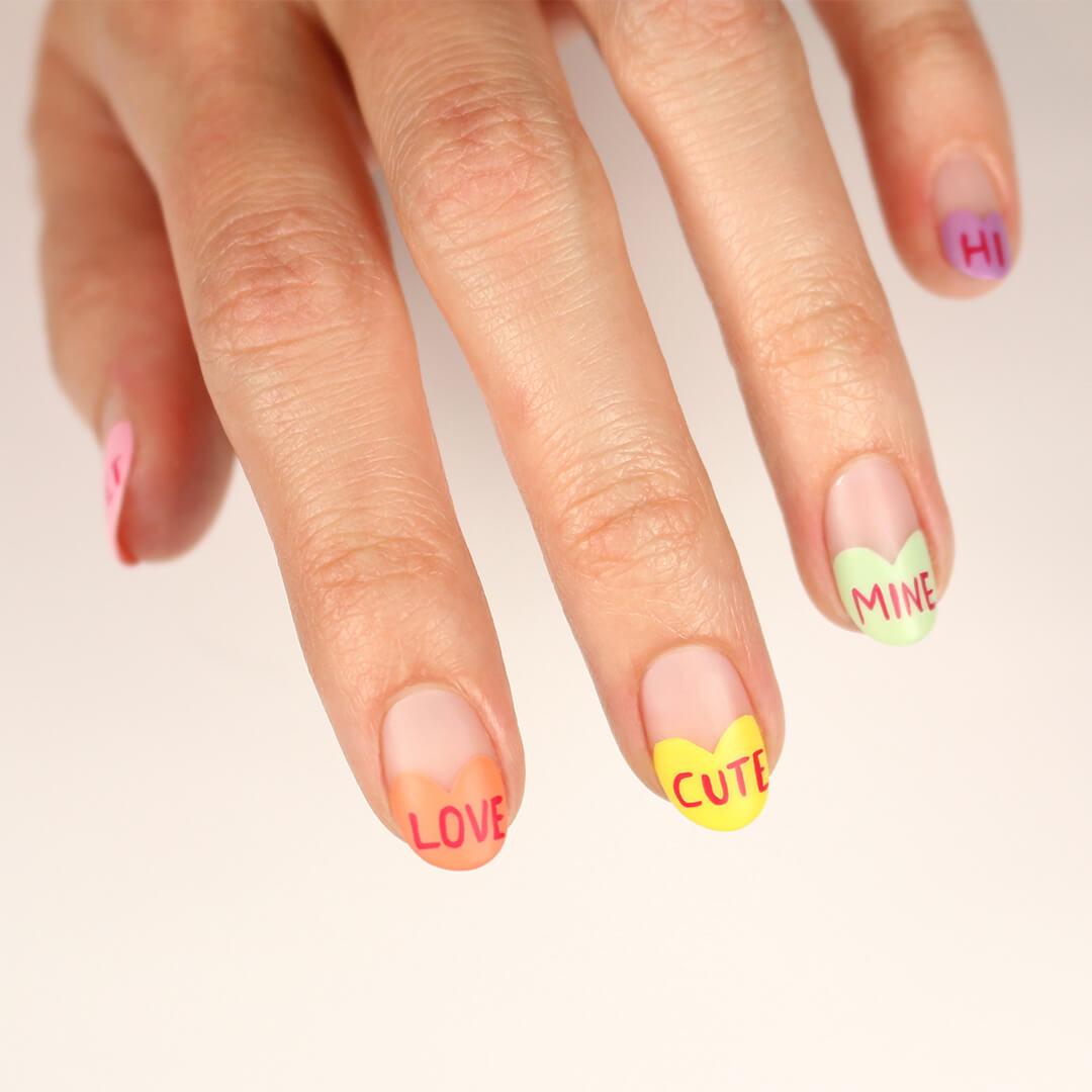 Image of model's hand with colorful nail art with words Desktop
