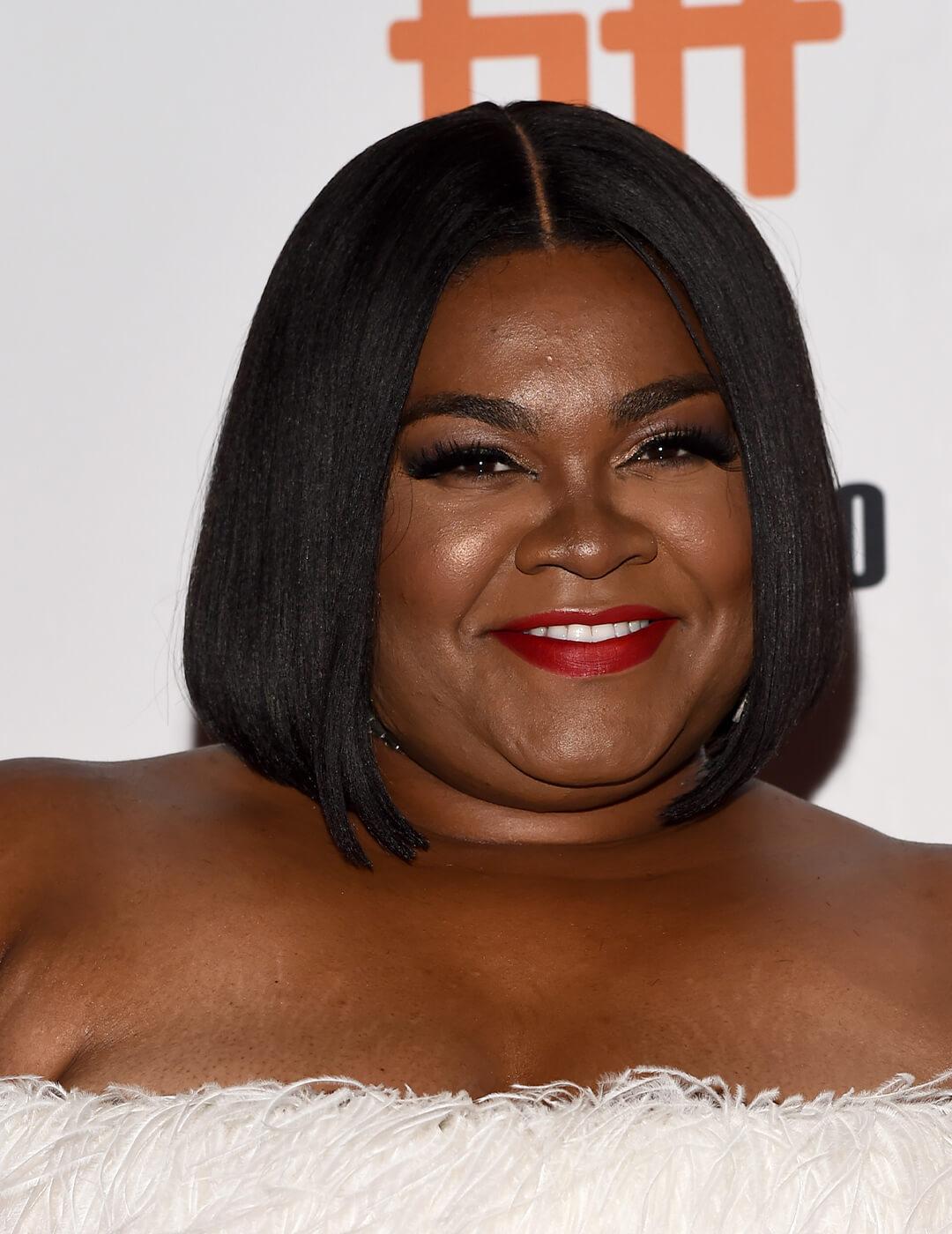 Da'Vine Joy Randolph in a white, feathery dress rocking a blunt bob hairstyle Mobile