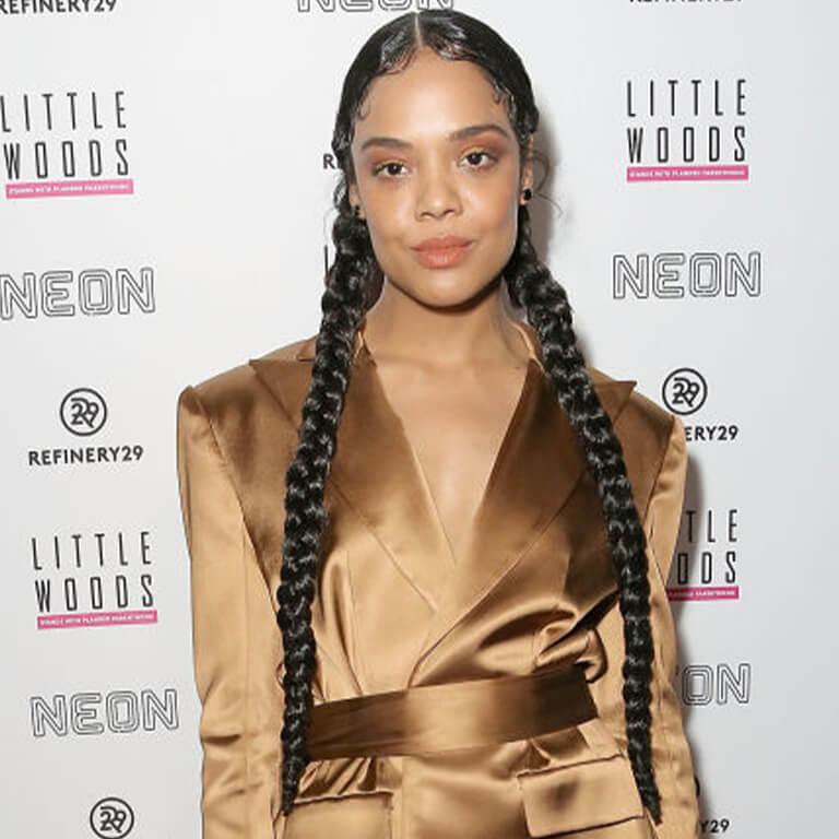 An image of Tessa Thompson showing her very long braided pig tail hairstyle Desktop