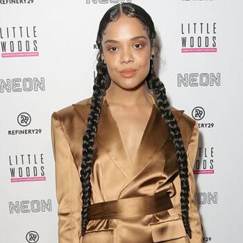 An image of Tessa Thompson showing her very long braided pig tail hairstyle Mobile
