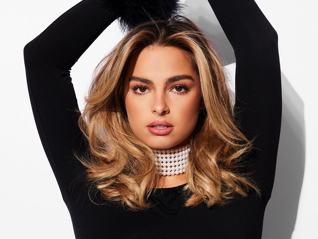 Glam Addison Rae in black posing against white background Desktop