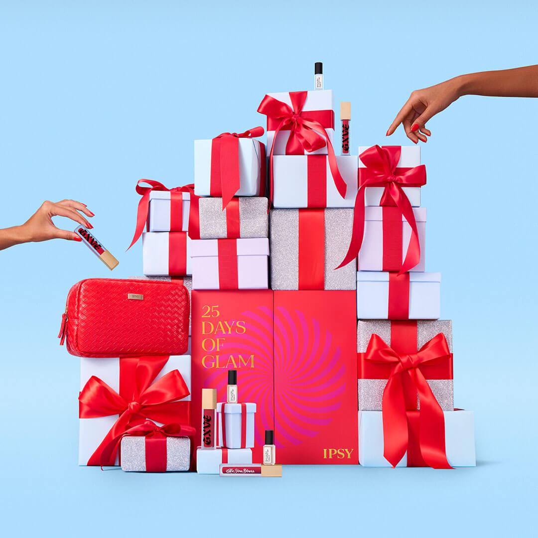 Stack of holiday gifts and beauty products with two hands plucking products off the stack Desktop
