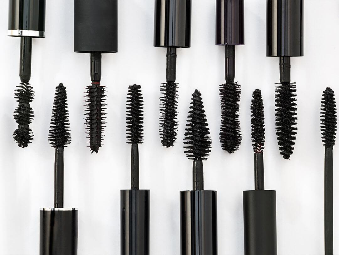 A picture featuring a row of several black mascara brushes against a white backdrop Desktop