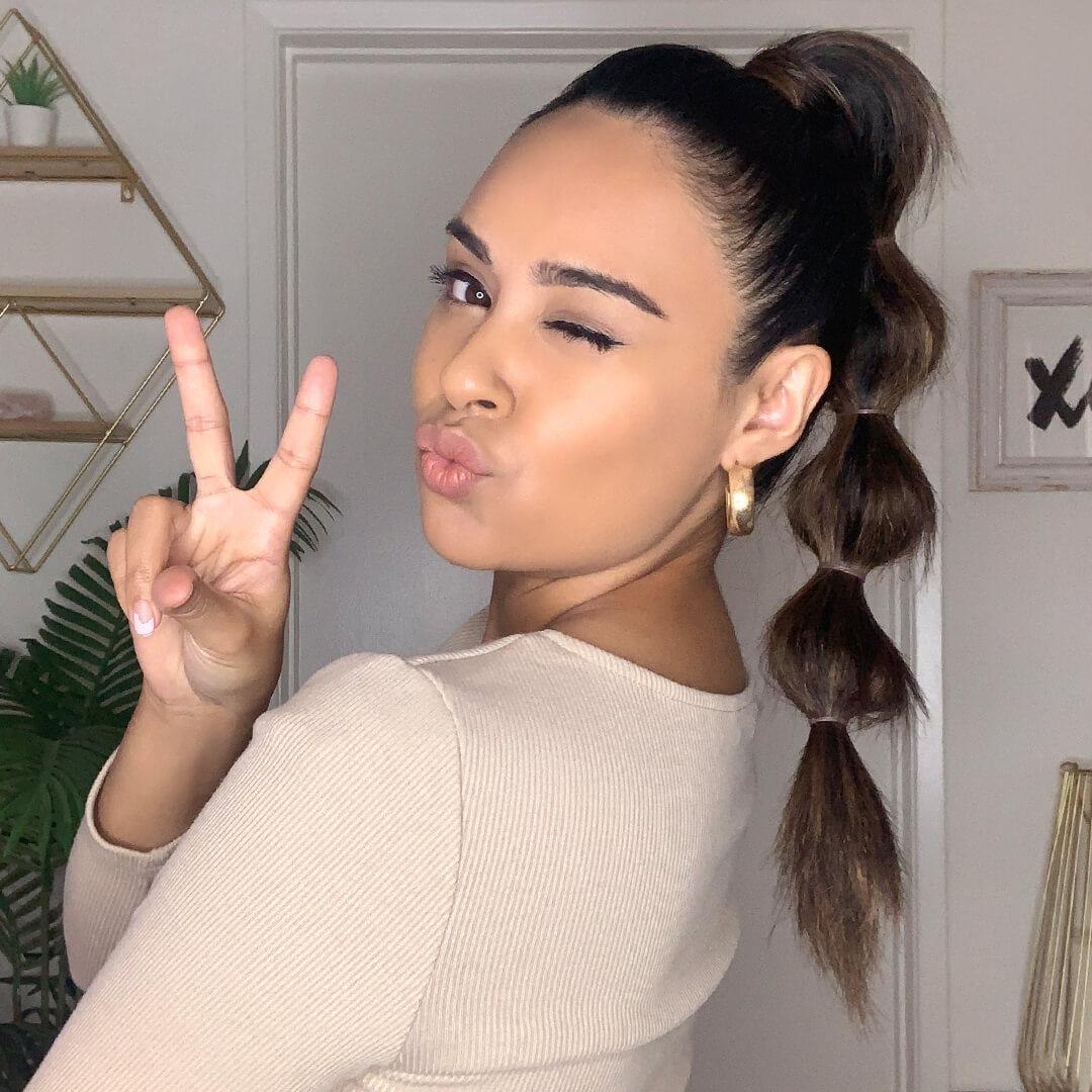 Cynthia Dhimdis giving a peace sign while winking and pouting Desktop