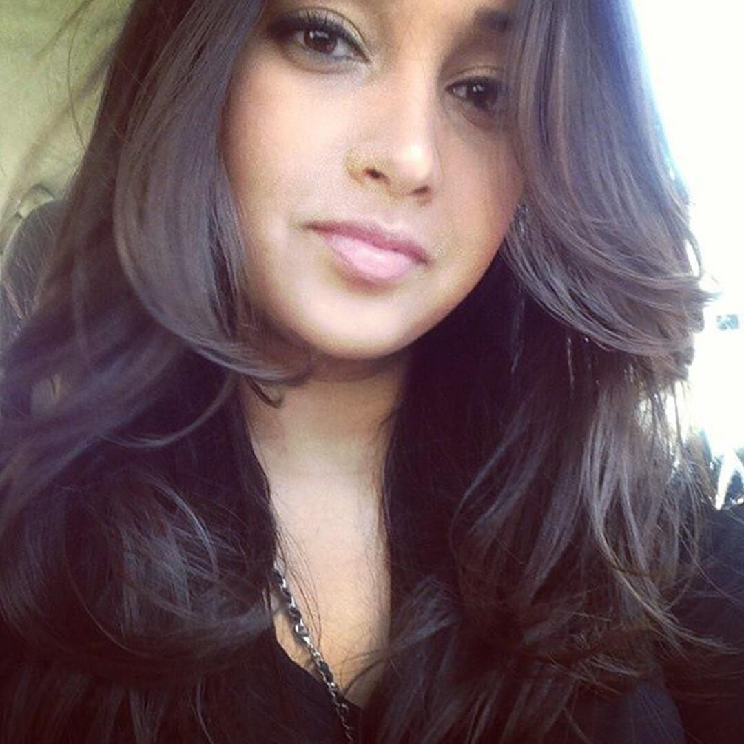 Close-up image of Pia Bhattacharya with big wavy hair wearing a black outfit Desktop