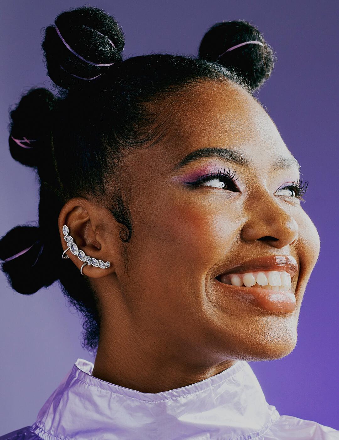 Futuristic afro American woman thinking about the future. Sporty young lady with funky hair and piercings grinning in happiness. Fashion model poses for hip and trendy store catalogue Desktop