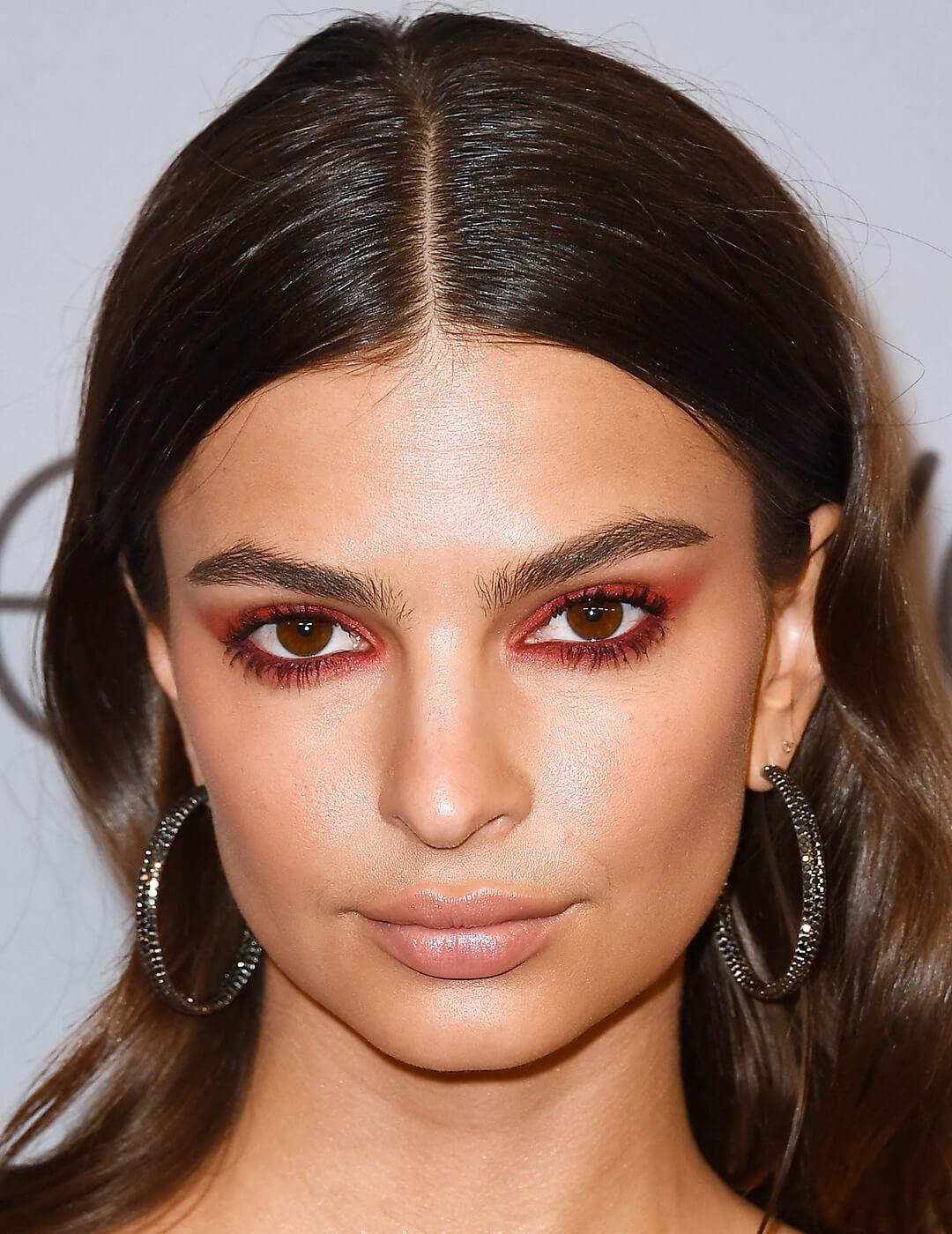Close-up of Emily Ratajkowski rocking a red eye makeup look and black hoop earrings Desktop