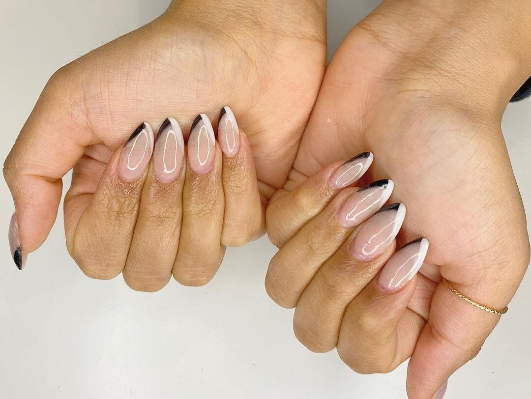 Close-up of a woman's hands with black and white V-cut French manicure nail art Desktop
