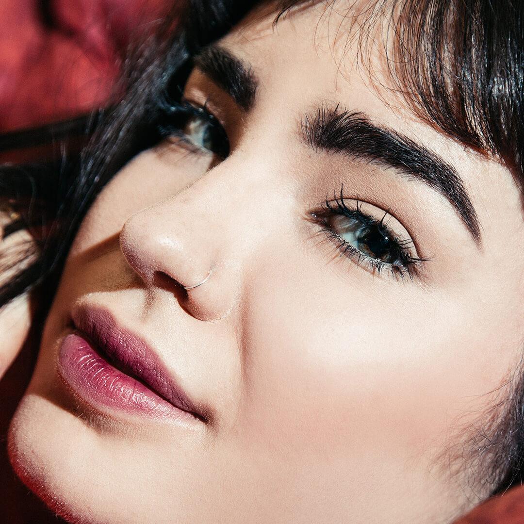 A closeup photo of a model's face with long doll lashes Desktop