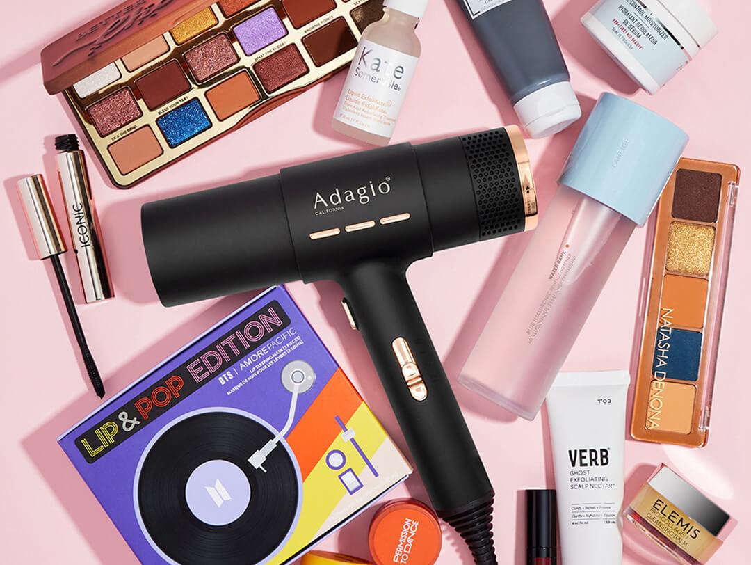 Beauty and makeup products and tools from various brands scattered on pink background Desktop