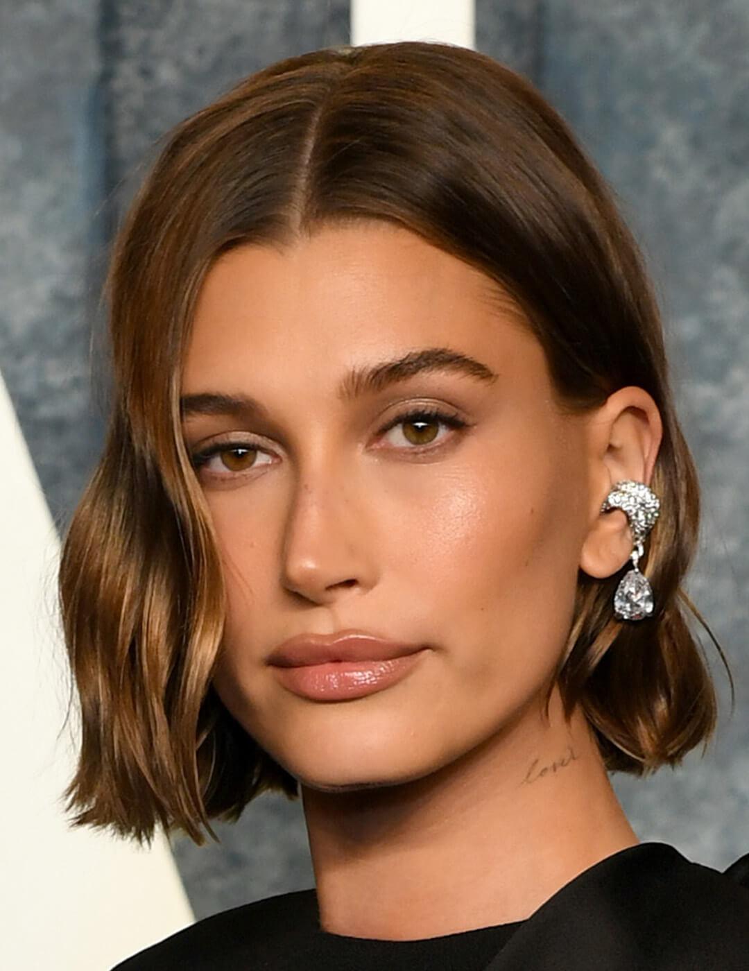 Close-up look of Hailey Bieber rocking a subtle makeup style, paired with her chic blunt mini bob hairstyle with Crystal Clip Earrings in a stylish tear-drop design Desktop