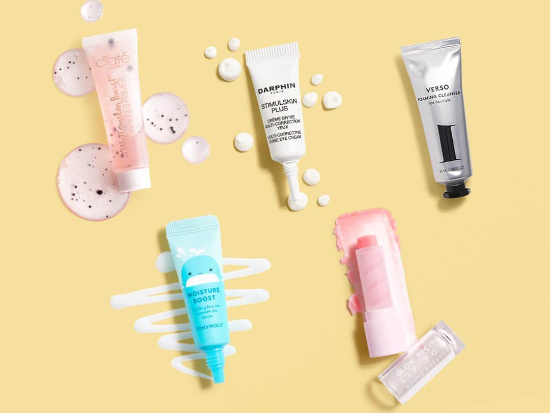 Beauty products from various brands swatched on yellow background Desktop